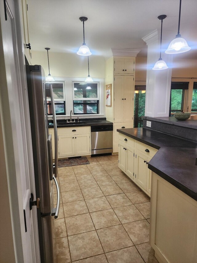 kitchen featuring hanging light fixtures, sink, light tile patterned floors, and stainless steel appliances