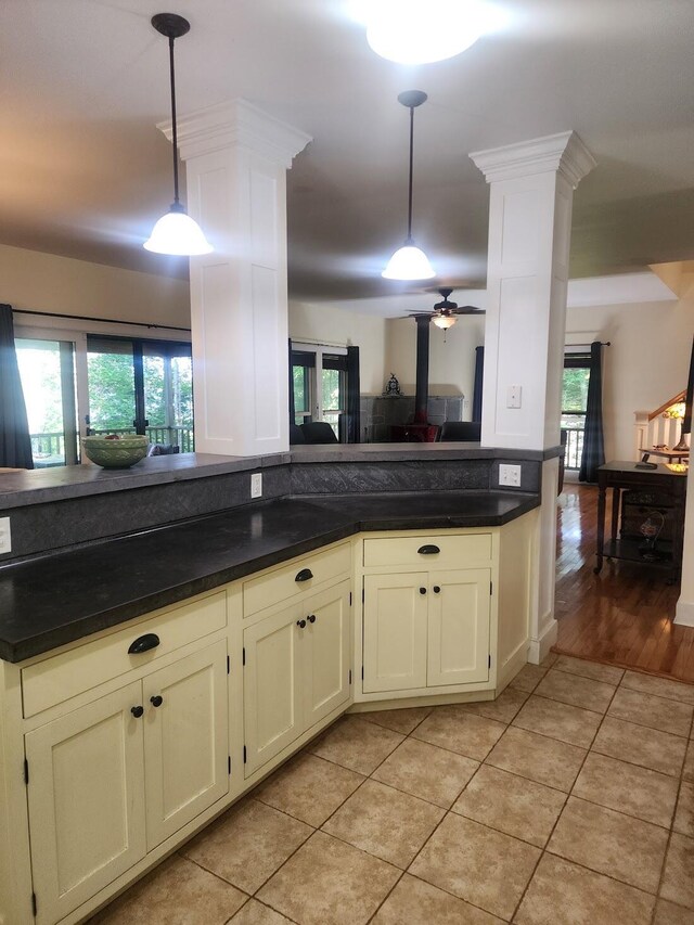 kitchen with hanging light fixtures, ornate columns, light tile patterned floors, and ceiling fan