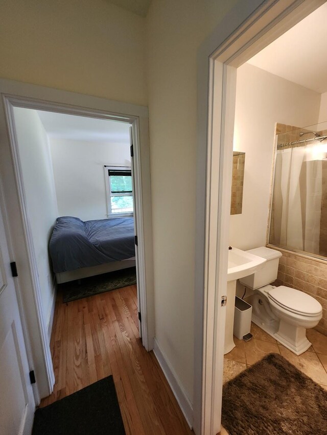 bathroom featuring hardwood / wood-style flooring and toilet