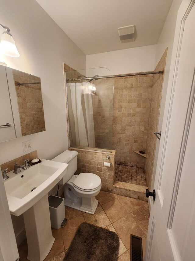 bathroom featuring tile patterned flooring, a shower with shower curtain, and toilet