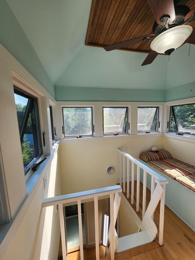 stairs with light hardwood / wood-style floors, vaulted ceiling, and ceiling fan