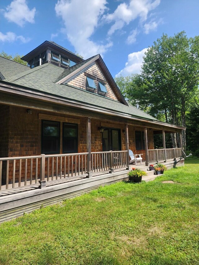 view of front of house with covered porch and a front lawn