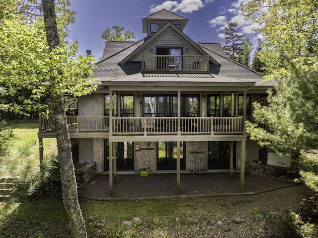 166 Kingfisher Trl, Perry, ME 04667 - rear view of property featuring a balcony, roof with shingles, a patio, and stone siding