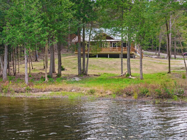 view of yard with a deck with water view