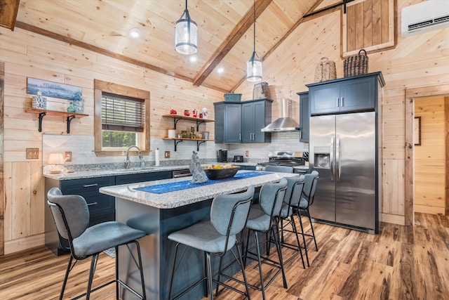 kitchen with light hardwood / wood-style flooring, stainless steel refrigerator with ice dispenser, wall chimney range hood, and a center island