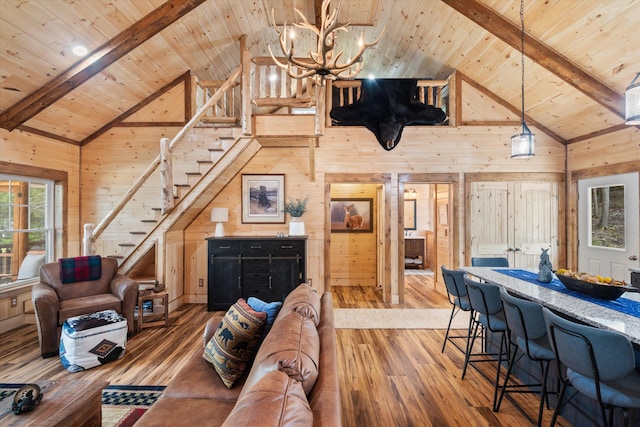 living room with beamed ceiling, wood walls, hardwood / wood-style floors, and wooden ceiling