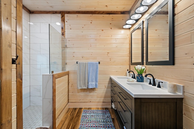 bathroom featuring hardwood / wood-style flooring, wooden walls, and vanity