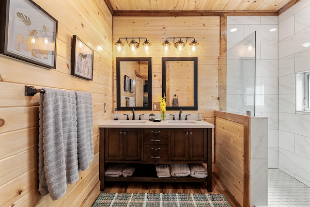 bathroom featuring tiled shower, double sink vanity, hardwood / wood-style floors, wood walls, and wood ceiling