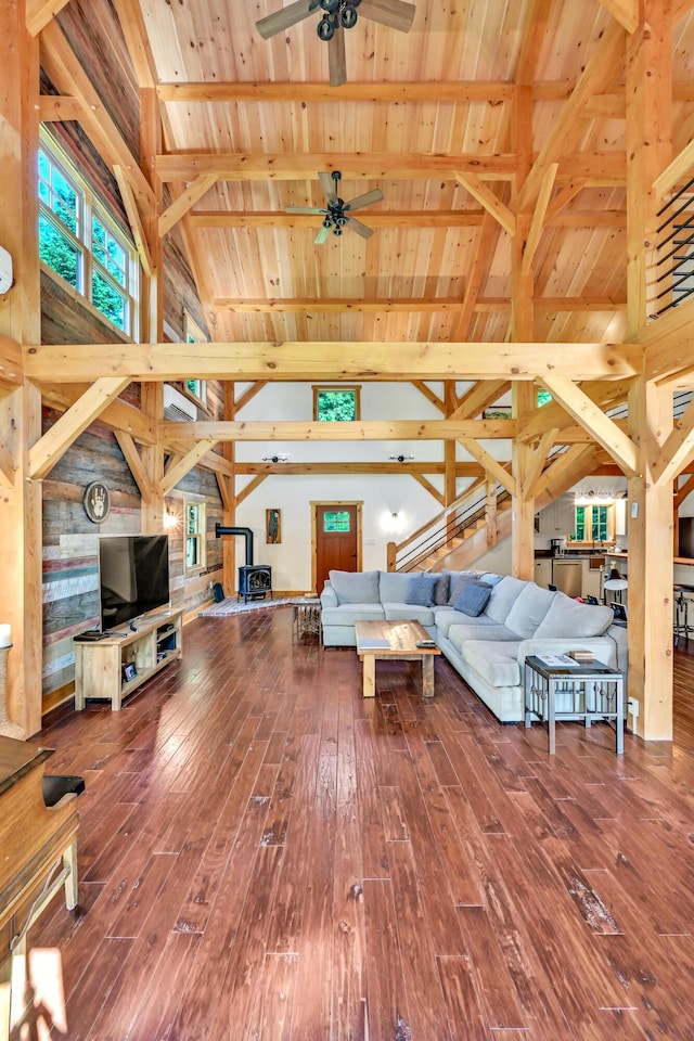 living room featuring hardwood / wood-style floors, high vaulted ceiling, beamed ceiling, ceiling fan, and wooden ceiling