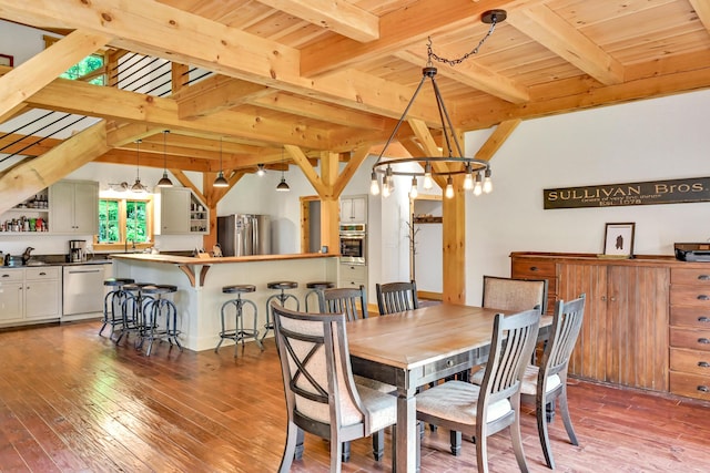 dining area with beam ceiling, wood ceiling, and hardwood / wood-style flooring