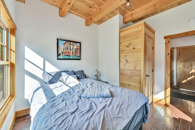 bedroom with beamed ceiling, dark wood-type flooring, and wooden ceiling