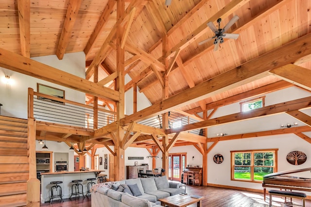 living room with ceiling fan, beam ceiling, dark hardwood / wood-style floors, and a healthy amount of sunlight