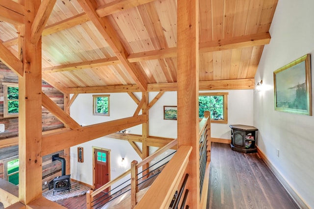 hallway featuring vaulted ceiling with beams, dark wood-type flooring, and wooden ceiling