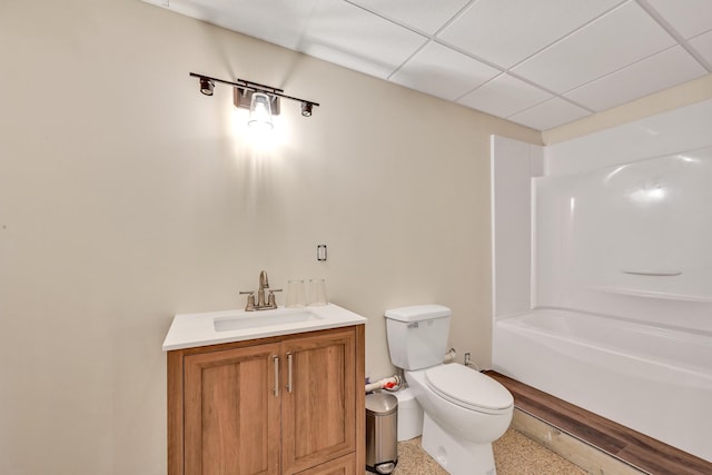 bathroom with vanity, toilet, and a drop ceiling