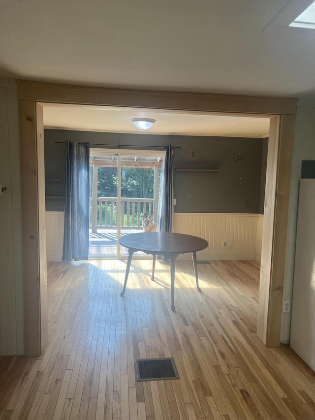 63 Rebel Hill Rd, Merrill, ME 04780 - unfurnished dining area with wood finished floors, visible vents, and wainscoting