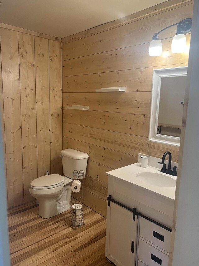 63 Rebel Hill Rd, Merrill, ME 04780 - bathroom with vanity, toilet, wood finished floors, and wooden walls