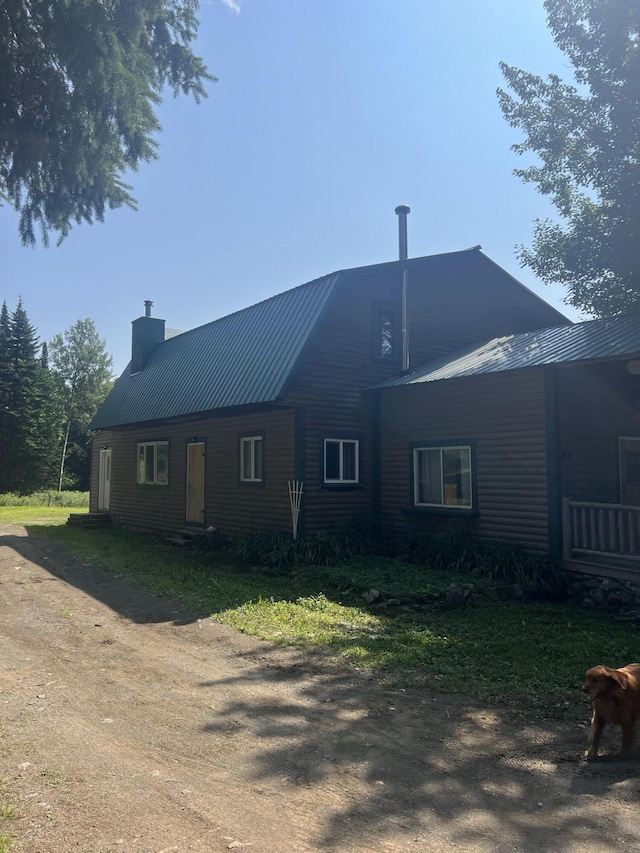 63 Rebel Hill Rd, Merrill, ME 04780 - back of house with dirt driveway, a chimney, and metal roof