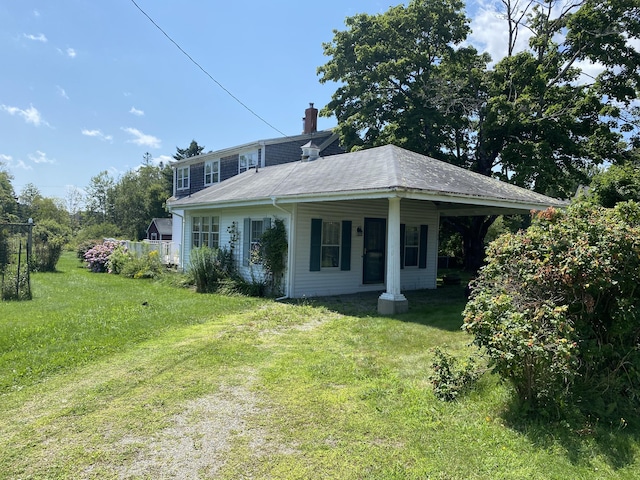 view of front of home with a chimney and a front lawn