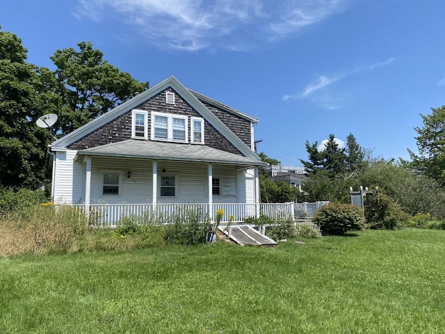 back of house featuring a yard and covered porch