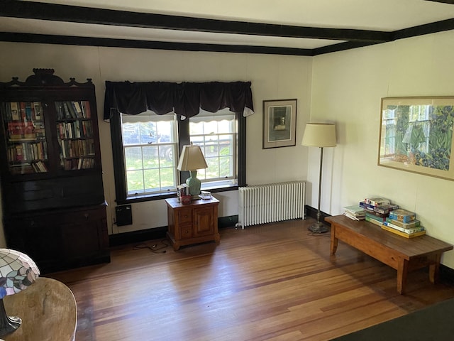 interior space featuring hardwood / wood-style floors, beamed ceiling, and radiator