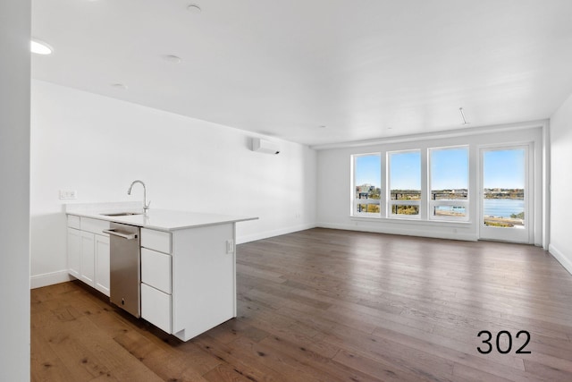 kitchen with white cabinetry, sink, dark hardwood / wood-style floors, and a water view