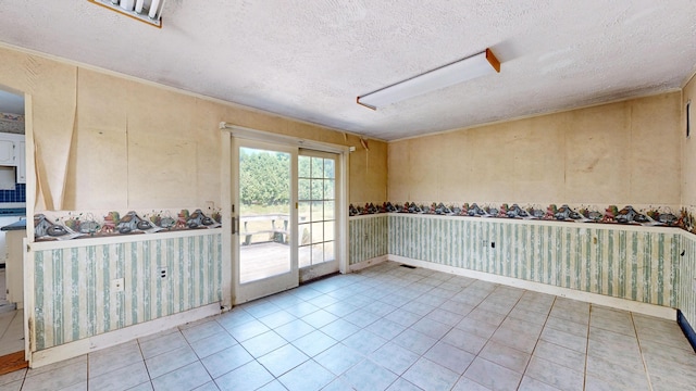 tiled empty room with a textured ceiling