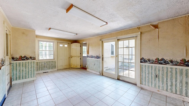 interior space featuring ornamental molding, light tile patterned floors, and a textured ceiling