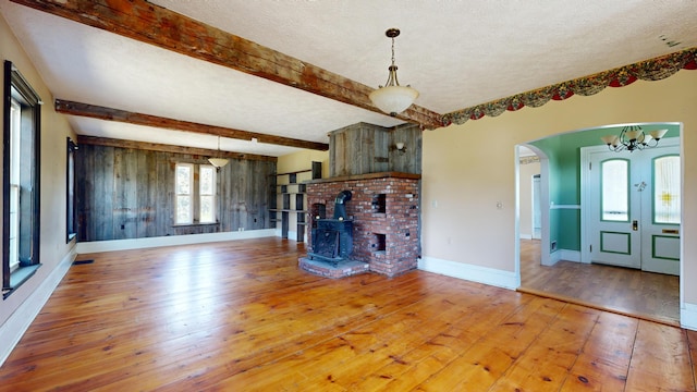 unfurnished living room with beam ceiling, hardwood / wood-style floors, and a textured ceiling