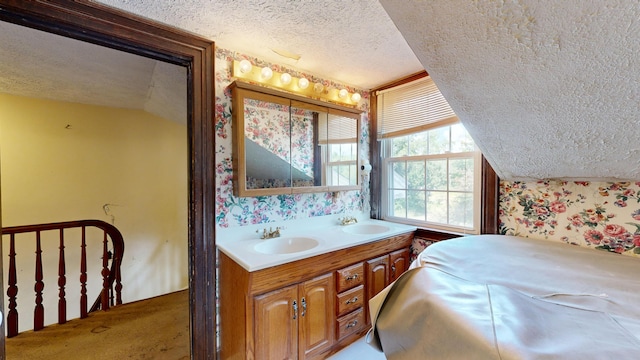 bathroom featuring vanity, vaulted ceiling, and a textured ceiling