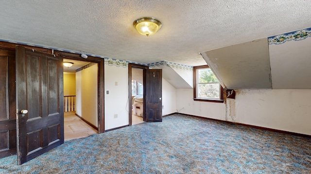 additional living space featuring light colored carpet and a textured ceiling