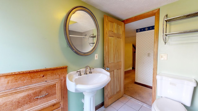 bathroom with tile patterned floors, a textured ceiling, and toilet