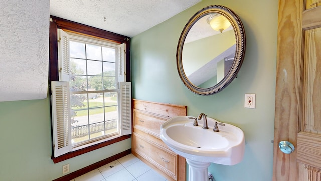 bathroom featuring tile patterned floors, sink, and a textured ceiling