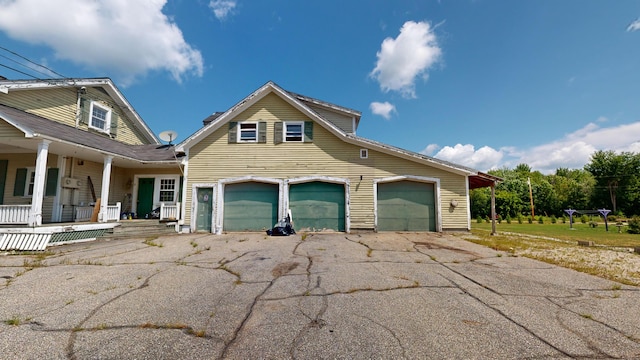 view of property exterior featuring a porch and a garage