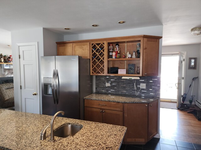 kitchen with sink, light stone counters, decorative backsplash, dark hardwood / wood-style floors, and stainless steel refrigerator with ice dispenser