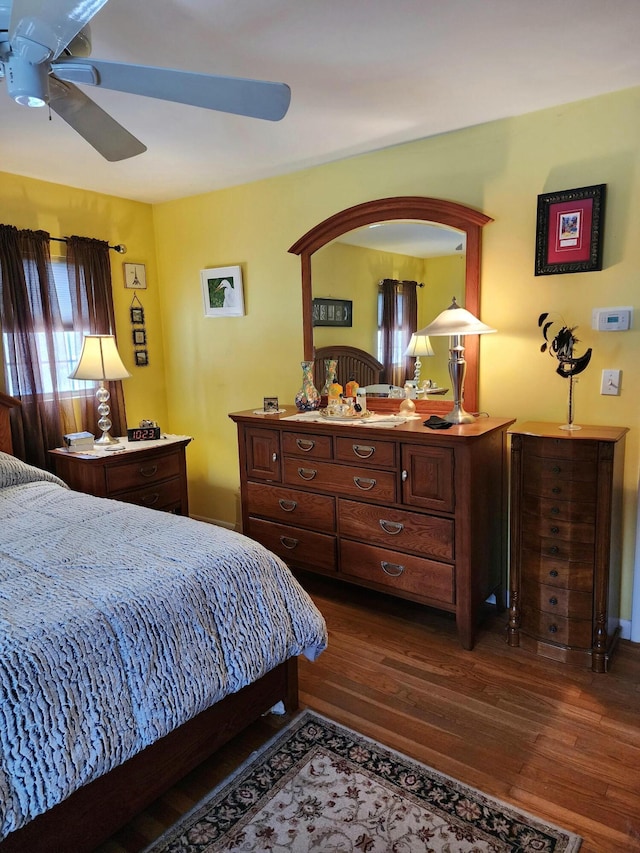 bedroom with a ceiling fan and dark wood-style flooring