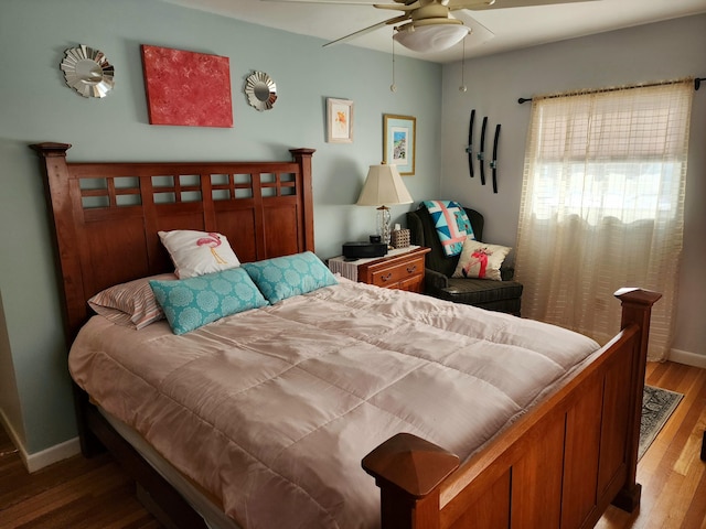 bedroom with baseboards, wood finished floors, and a ceiling fan