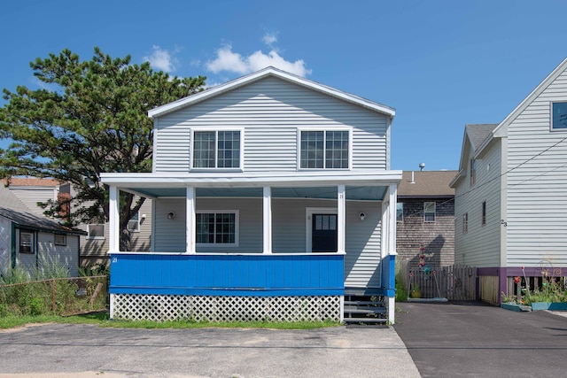 view of front facade with a porch and fence