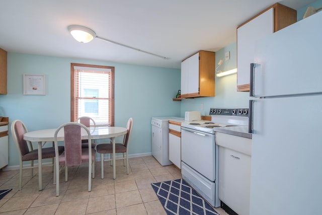 kitchen with light tile patterned floors, white appliances, white cabinetry, light countertops, and washer / dryer