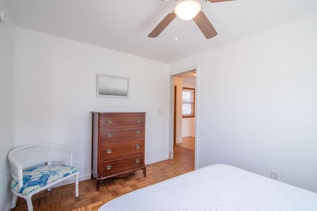 bedroom with a ceiling fan and baseboards