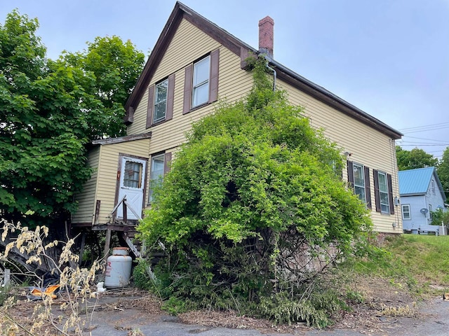 view of property exterior featuring a chimney