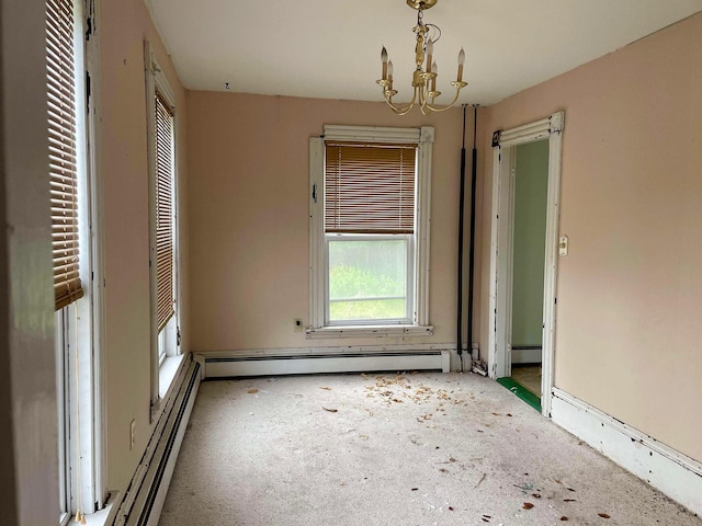 spare room featuring a notable chandelier and baseboard heating