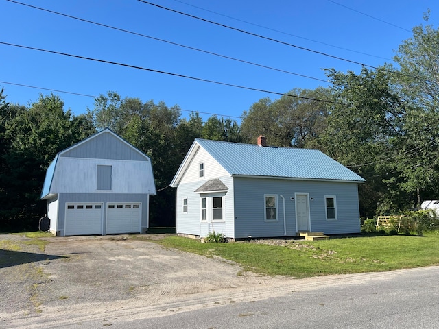 view of front of house with a garage, an outdoor structure, and a front yard