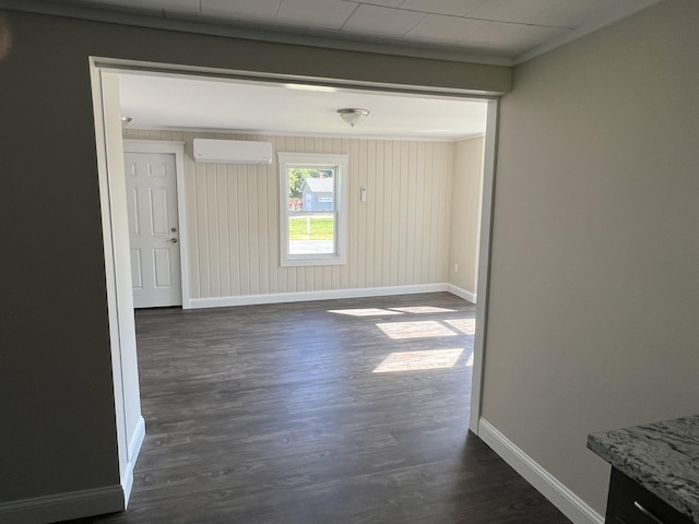 spare room with ornamental molding, dark wood-type flooring, and a wall unit AC