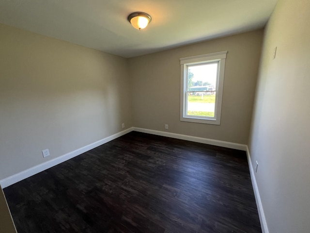 unfurnished room with dark wood-type flooring