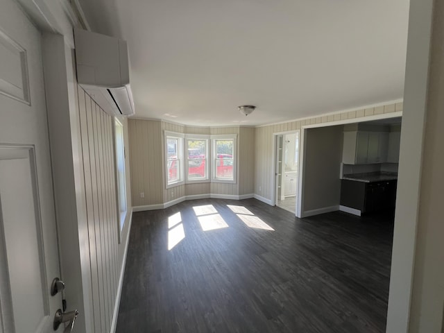 interior space with a wall unit AC and dark hardwood / wood-style floors