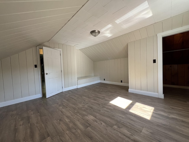 additional living space with dark wood-type flooring and vaulted ceiling