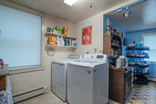 laundry area featuring washing machine and clothes dryer, light tile patterned floors, and a baseboard radiator