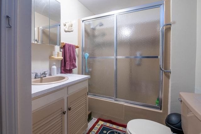 full bathroom with bath / shower combo with glass door, toilet, and vanity