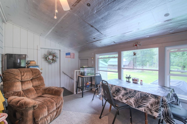 carpeted dining room featuring ceiling fan and vaulted ceiling