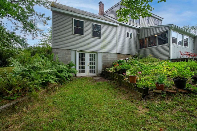 back of property featuring french doors, a sunroom, and a yard